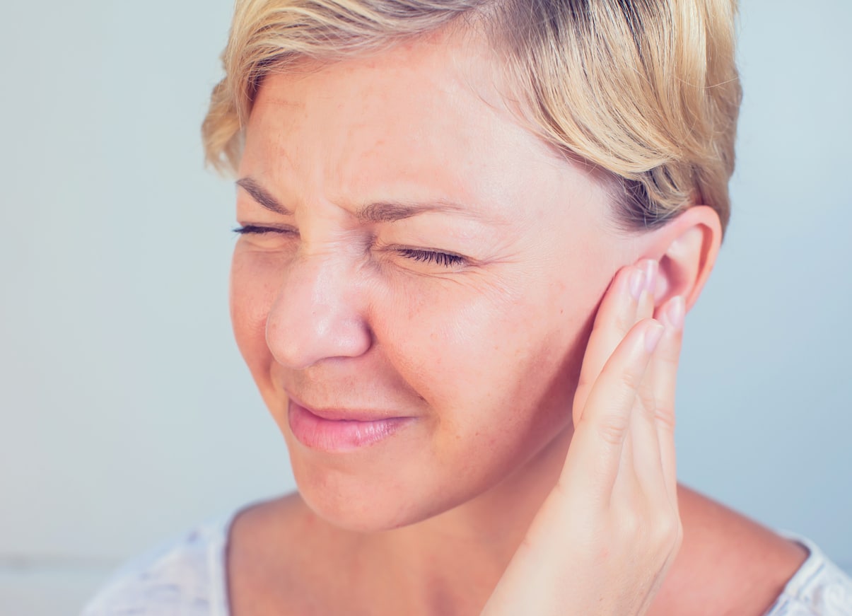 Woman with tinnitus holding her ear