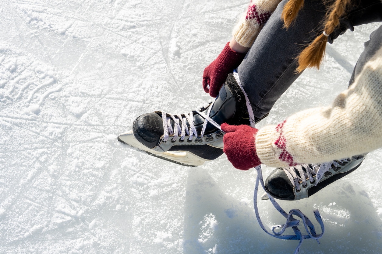 Woman lacing up her skates at the ice rink