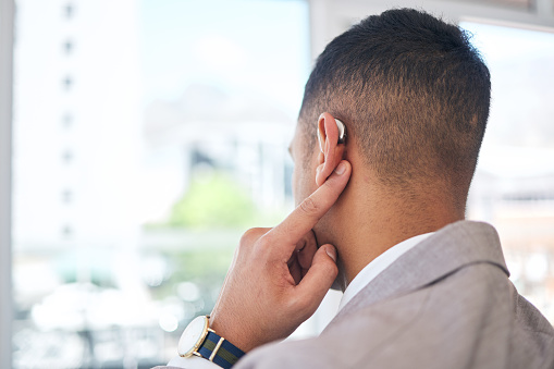 Back, business man and hearing aid for ear, sound amplifier and audio communication in company office. Professional,